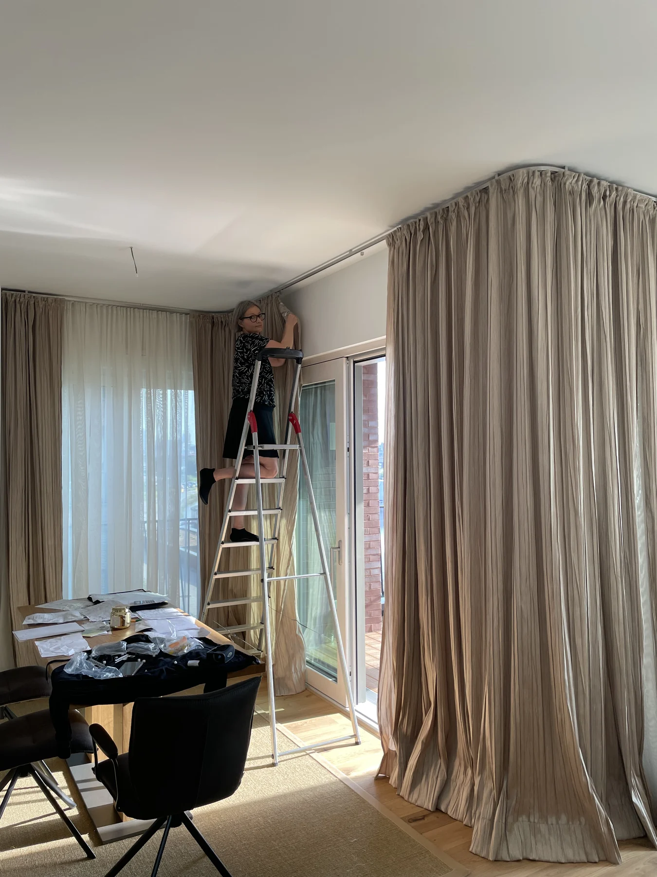 Montage bodenlanger Gardinen und transparenter Vorhänge an einer Fensterfront