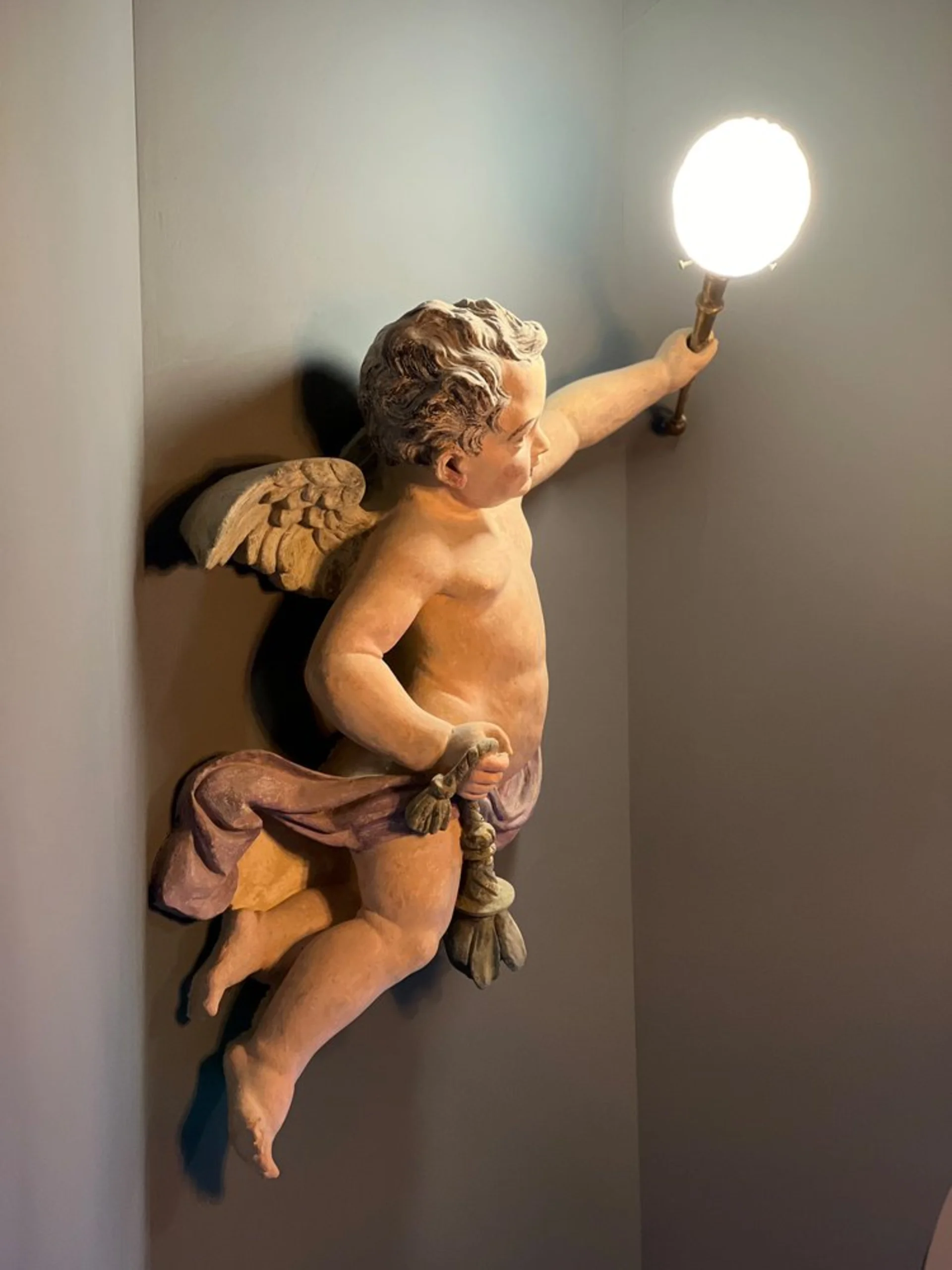Treppenabsatz mit restaurierter Engelsfigur als Wandleuchte