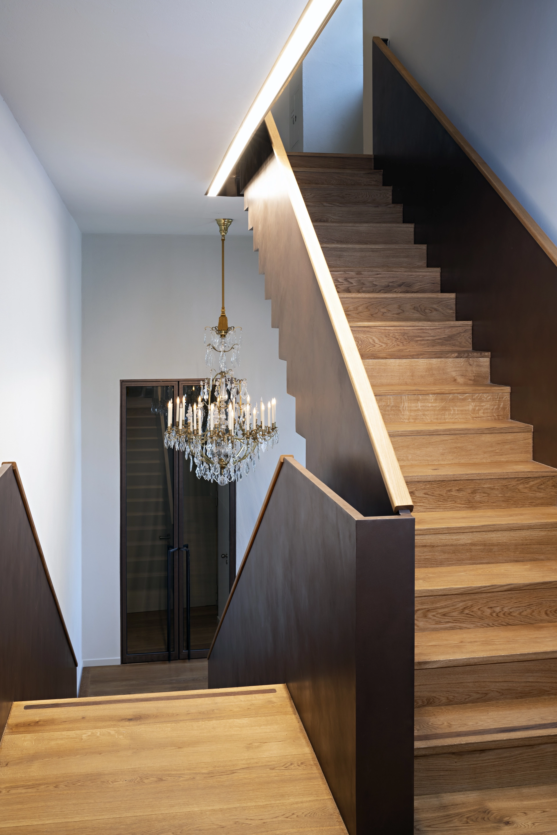 Schloss – moderne Metalltreppe mit historischem Lüster