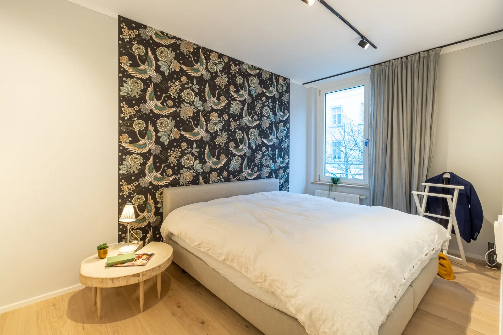 Schlafzimmer mit dunkler Kranich-Tapete
